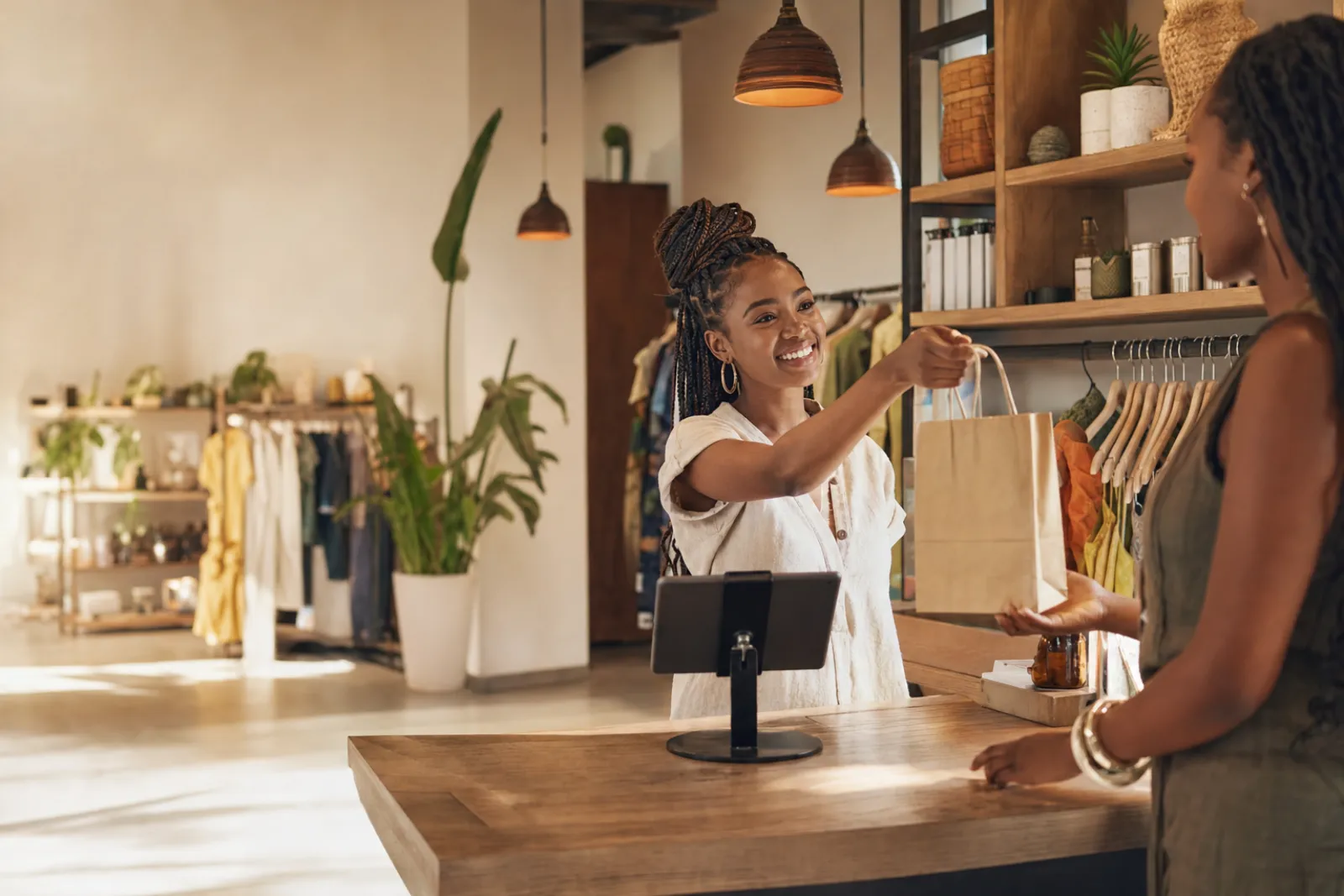 A boutique owner serves a customer at her counter
