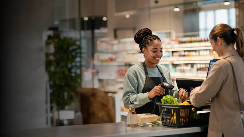 A cashier scans groceries at a minimart checkout